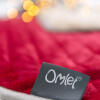 Omlet label op een rode Luxwondendeken voor katten en honden