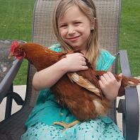 Mijn kleindochter die 2 kippen op haar schouders heeft.