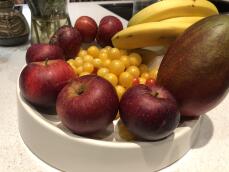 Tomaten appels bananen en een manGo in een fruitschaal