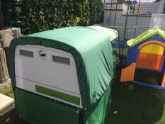 Een groot Eglu Cube kippenhok met een overkapping voor alle weersomstandigheden er overheen