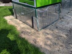 Een Eglu Cube kippenhok met doorzichtige kappen eronder.