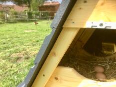 Een close-up foto van het nestgedeelte van een houten kippenhok