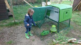 Meisje met Omlet groen Eglu Cube groot kippenhok en ren in tuin