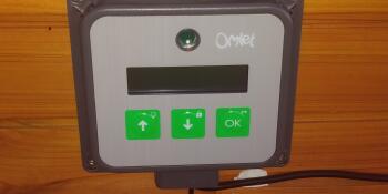 Een foto van het bedieningspaneel van de Omlet automatische deuropener.