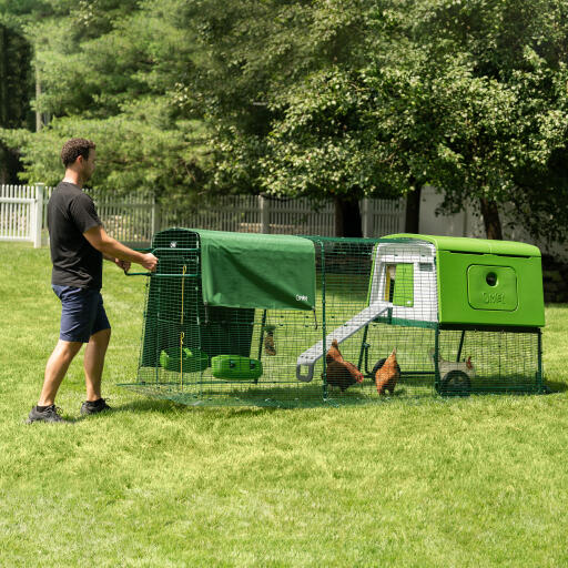 Man die het Eglu Cube verplaatsbaar kunststof kippenhok verplaatst
