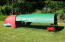 Rood Eglu Classic kippenhok met ren en over de gehele lengte een groene afdekking die schaduw biedt in de tuin
