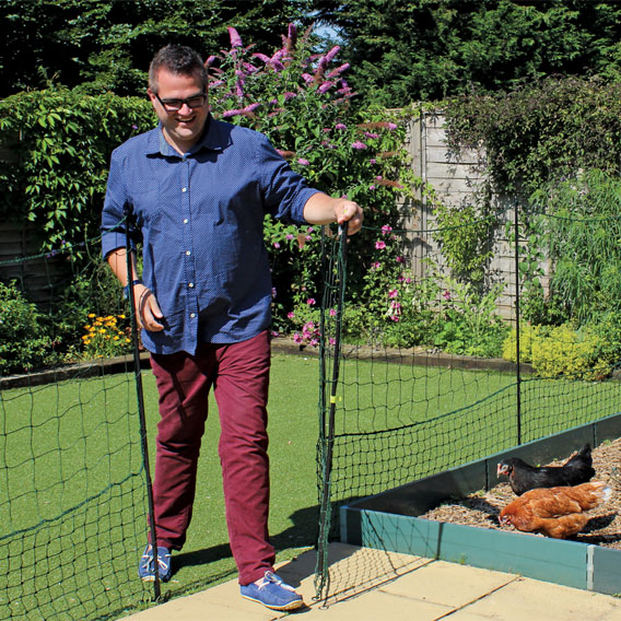 Man operating the Omlet chicken fencing gate.