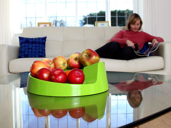 Een groene Rollabowl gevuld met fruit op de salontafel