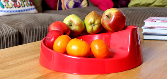 en rode Rollabowl fruitschaal op een salontafel