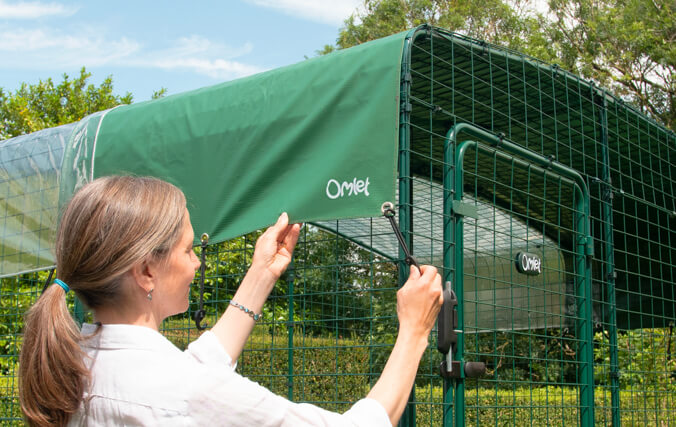 Woman attaching omlet run cover to a catio